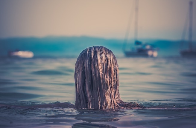 women surfacing from the ocean with wet hair