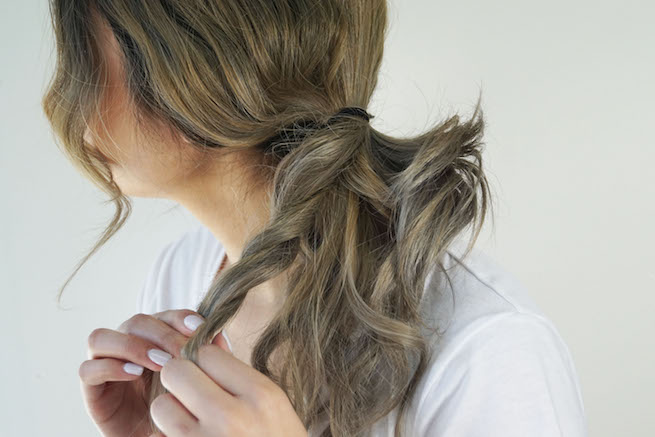 woman separating sections of a ponytail
