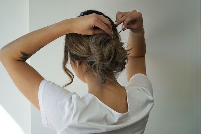 woman tying up a messy bun