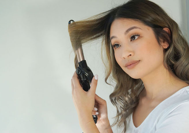woman using vs sassoon curling iron
