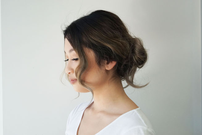 woman modelling a messy bun hairstyle profile view
