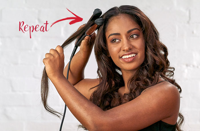Woman curling hair with a straightener